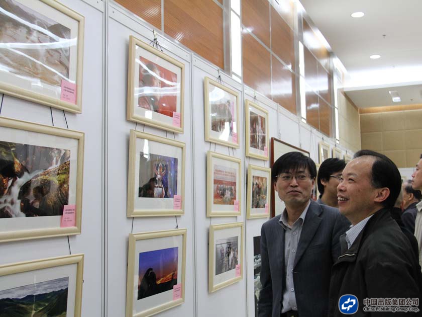 中版集团数字传媒有限公司总经理周锡培在书画摄影展览作品前驻足观赏
