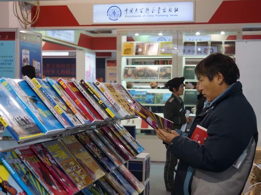 中国出版集团公司展区，读者在认真翻阅展书。