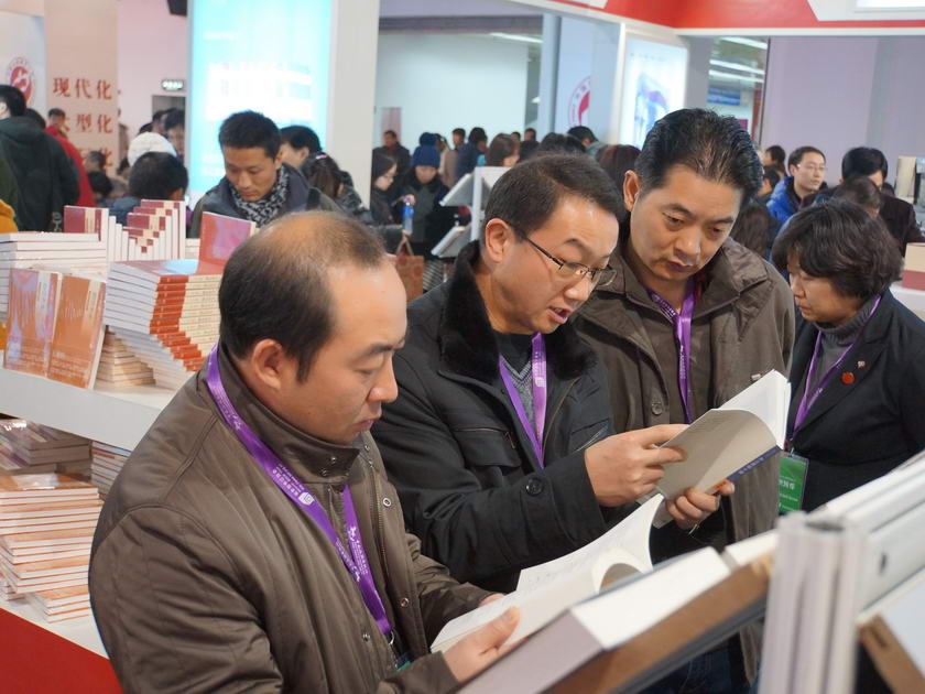 中国出版集团公司展区，读者在认真翻阅展书。