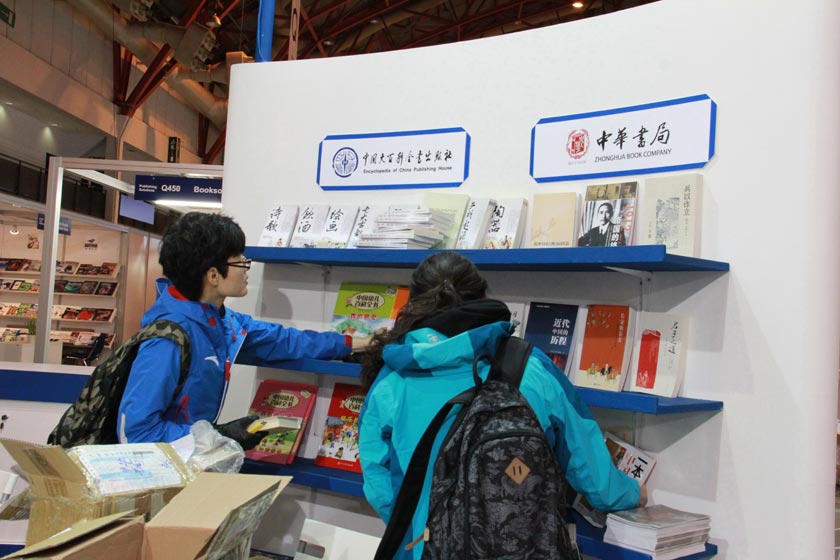 工作人员在上架中国大百科出版社、中华书局参展图书。