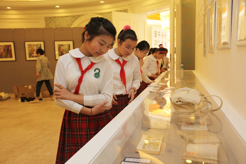 小朋友们聚精会神地观看绘本展作品。