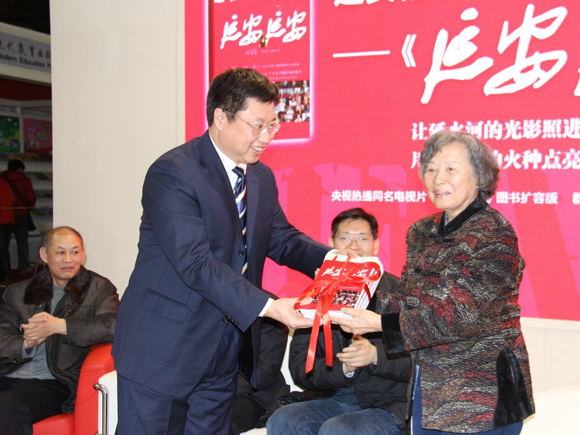 图为中国民主法制出版社社长肖启明赠予原国务院副总理兼外长黄华先生的夫人何理良图书。