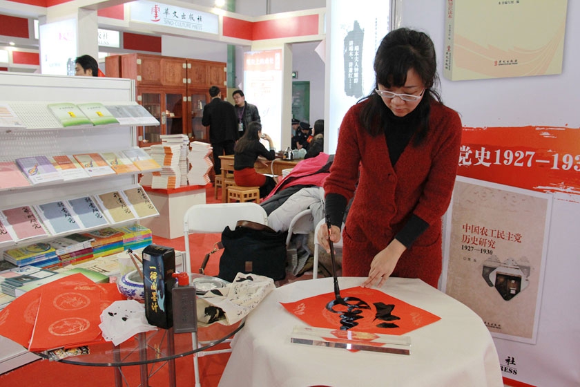 图为华文出版社展区现场书写“福”字并赠送读者