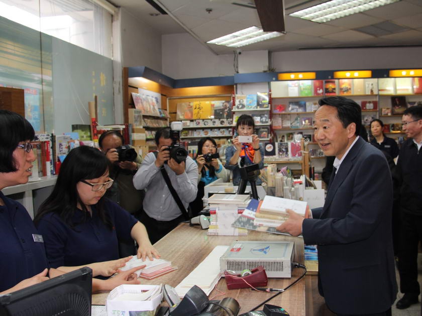 新闻出版广电总局党组书记蒋建国在收银台付款购书。（摄影：袁思源）