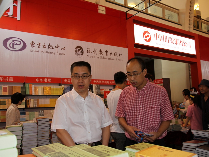 中国出版集团公司副总裁李岩（左）视察集团展区。