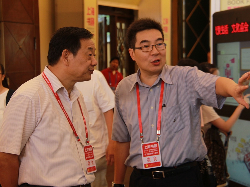 东方出版中心总编辑李智平向中国出版集团公司副总裁王俊国介绍书展情况。