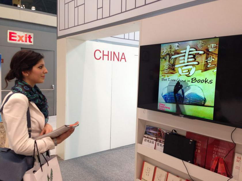 意大利读者Giulia被中国出版集团沙画形象片深深吸引，驻足观看。