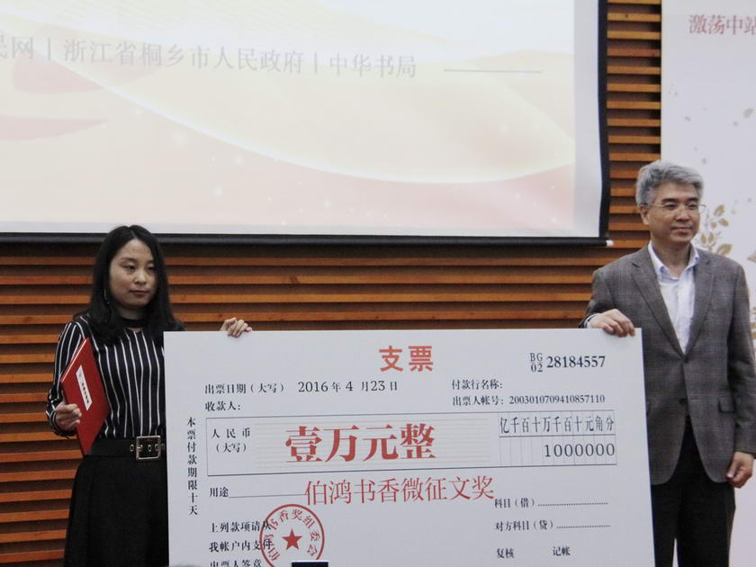 4月23日世界读书日，104岁的中华书局迎来了第二个“读者开放日”。第二届“伯鸿书香奖”颁奖典礼表彰了推动全民阅读的民间力量。图为人民网副总裁罗华（右一）为获得“我读《论语》”微征文奖的郝建博颁发证书和奖金。