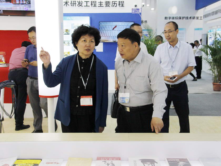 5月12日深圳文博会开幕，中国出版集团作为主宾团盛装亮相7号馆新闻出版馆。国家新闻出版广电总局印刷发行管理司司长王岩镔（左）视察中国出版集团展区并与中国出版集团党组成员、中国出版传媒股份有限公司副总经理樊希安交流。