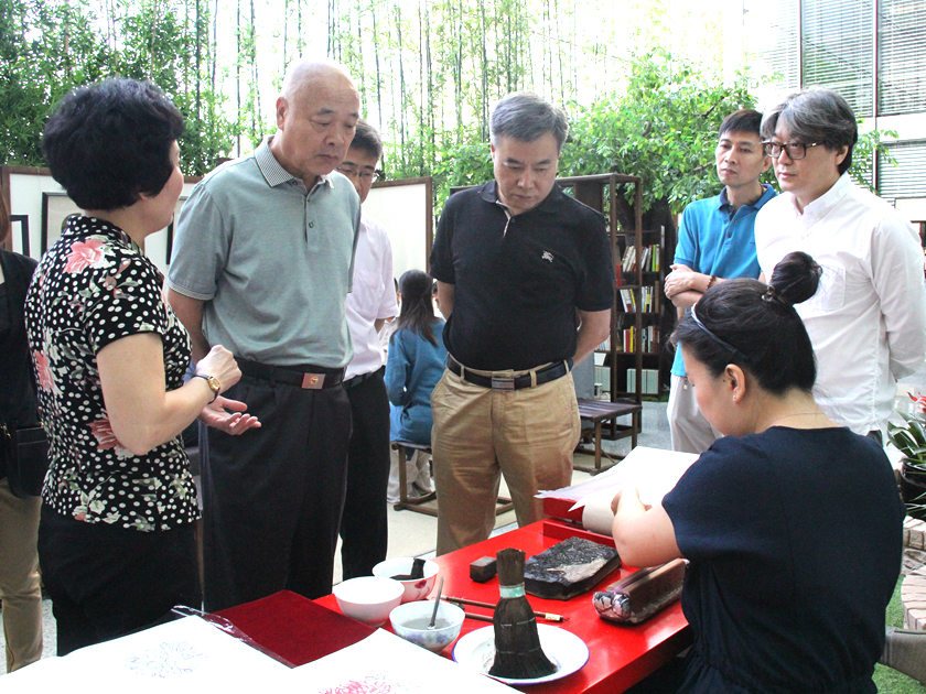8月16日，凯晨金茂书院暨荣宝斋茶文化开业仪式在北京举行。潘凯雄总裁、范存刚以及著名作家王树增（左二）共同欣赏木板水印制作演示及作品。