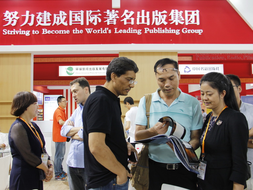 8月24日 ，在中国出版集团公司展区，  印度翻译家狄伯杰与中国同行进行交流。（摄影：李培芝）