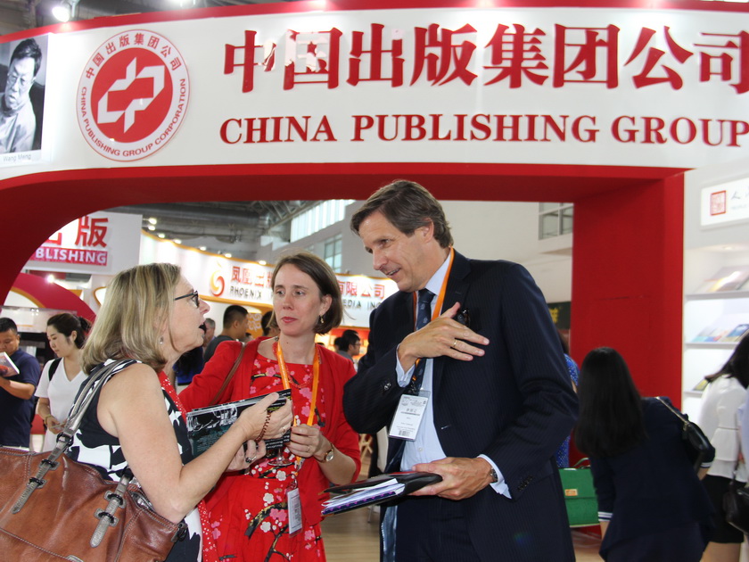 8月24日 ，在中国出版集团公司展区，参加书展的海外书商与专家进行交流。（摄影：李培芝）
