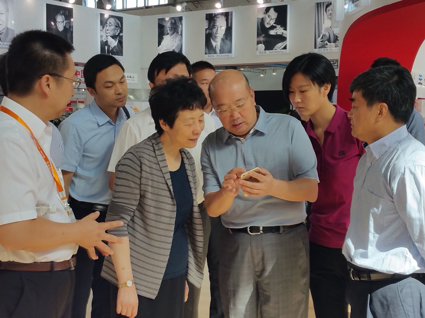 8月25日，全国人大常委会副委员长严隽琪，在国家新闻出版广电总局副局长吴尚之以及中国出版集团公司党组书记王涛，中国出版集团公司党组成员、中国出版传媒股份有限公司副总经理李岩的陪同下视察2016BIBF中国出版集团“主题出版”图书展区。王涛正在向严隽琪副委员长展示“中华古籍经典数据库”手机应用。（摄影：贾兵伟）