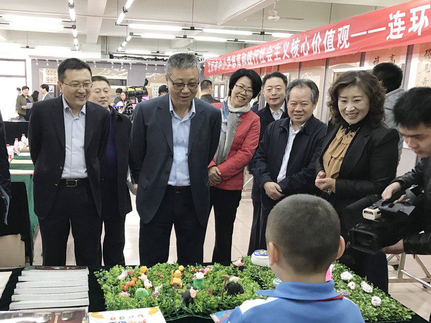 “北京市中小学培育和践行社会主义核心价值观——连环画进校园工作座谈会”全面总结三年来连环画进校园工作情况。图为中国出版集团副总裁刘伯根在人民美术出版社党委书记周伟的陪同下与小学生互动交流。
