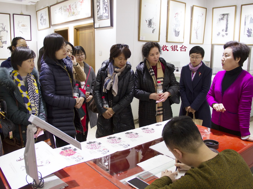 3月8日下午，中国出版集团总部女职工来到荣宝斋参观并体验木版水印技艺。图为非遗传承人高文英老师讲解演示勾描工序。