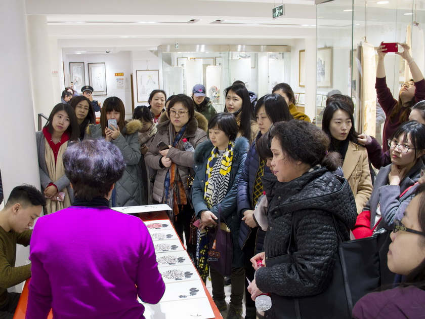 3月8日下午，中国出版集团总部女职工来到荣宝斋参观并体验木版水印技艺。图为非遗传承人高文英老师讲解演示勾描工序。