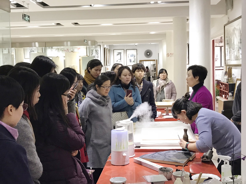 3月8日下午，中国出版集团总部女职工来到荣宝斋参观并体验木版水印技艺。图为非遗传承人高文英老师讲解演示印刷工序。
