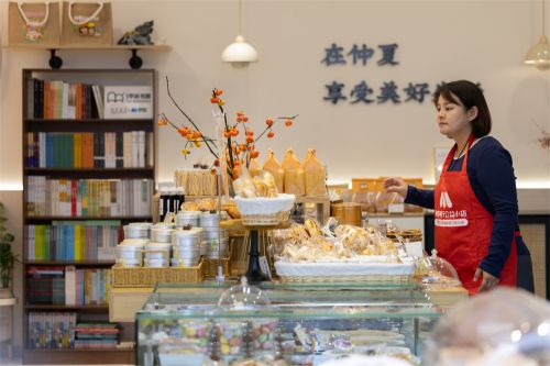 仲夏一心蛋糕面包集合店店主康盼盼腾出店里最好的位置放置书架。主办方供图